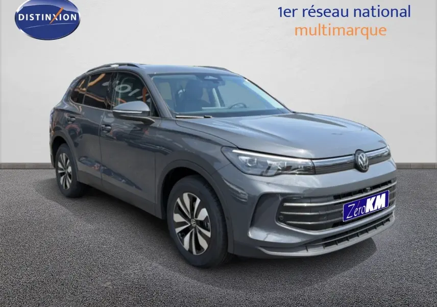 Volkswagen Tiguan gris dauphin métal en 3/4 avant droit avec calandre moderne et jantes bi-ton.