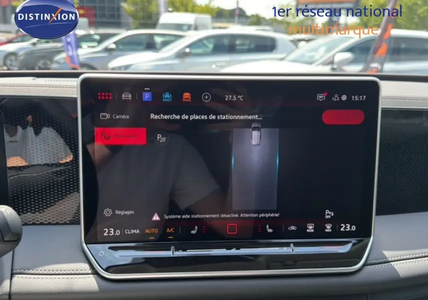 Vue intérieure centrée sur l'écran tactile du Volkswagen Tiguan gris dauphin, affichant l'assistance au stationnement.