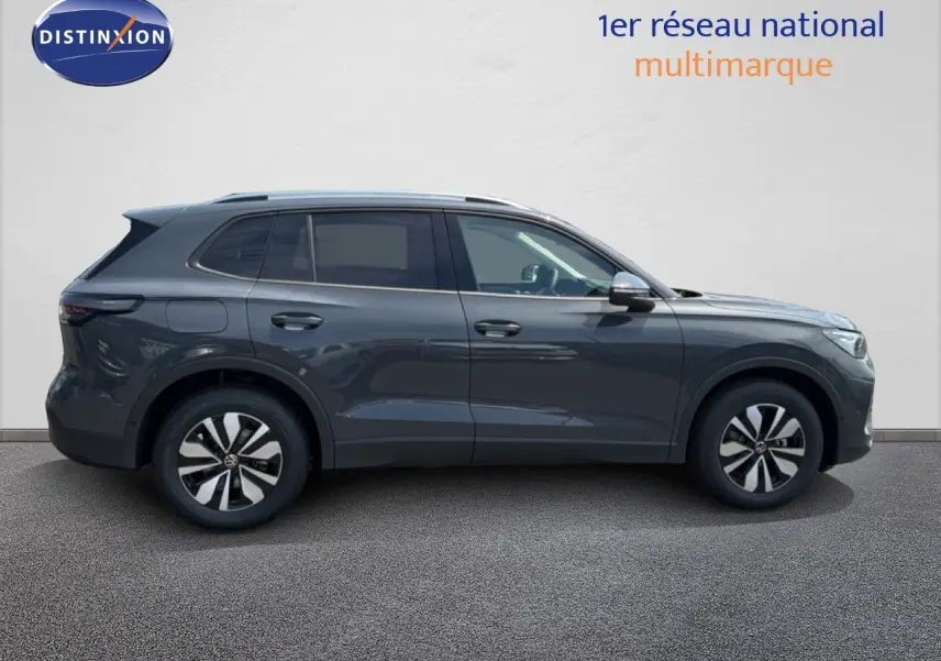 Profil droit d’un Volkswagen Tiguan gris dauphin métallisé 2026 avec jantes bi-ton et toit ouvrant.