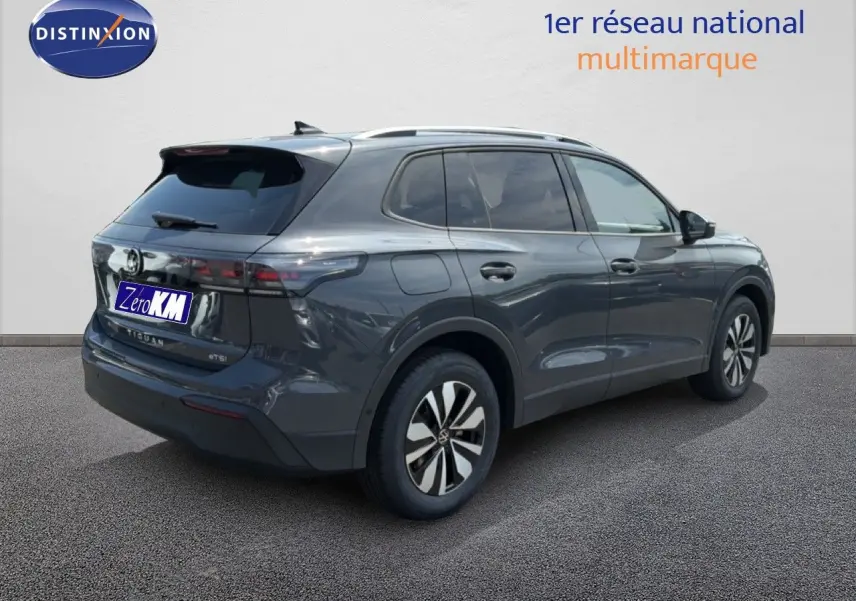 Volkswagen Tiguan gris dauphin métal vu en 3/4 arrière droit avec jantes alliage et vitres teintées.