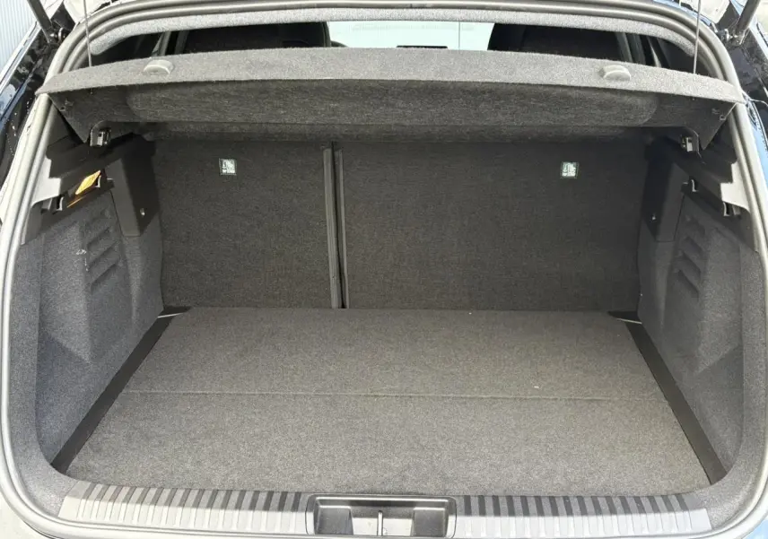 Coffre ouvert du Renault Symbioz noir étoile, vue intérieure montrant l'espace de rangement vide et la moquette grise.