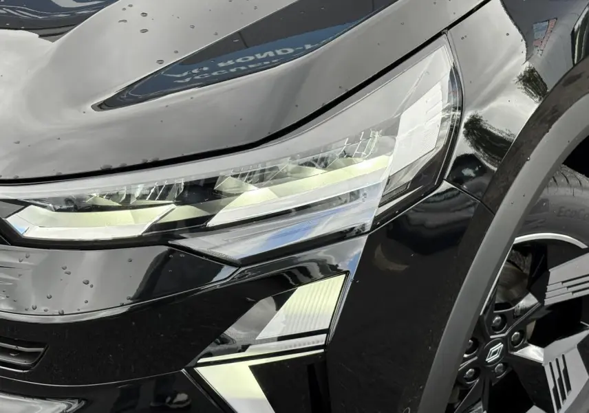 Gros plan sur le phare avant droit et la jante noire du Renault SYMBIOZ noir étoile 2025.