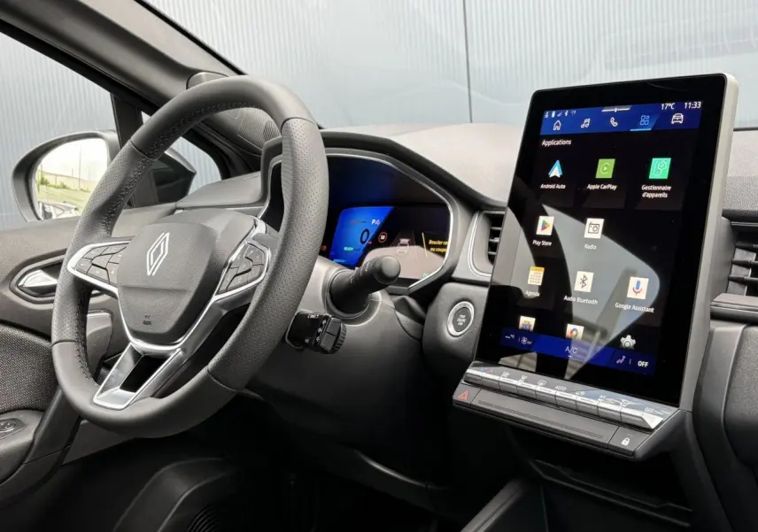 Vue intérieure côté conducteur du Renault Symbioz 2025, volant cuir et grand écran tactile vertical noir.