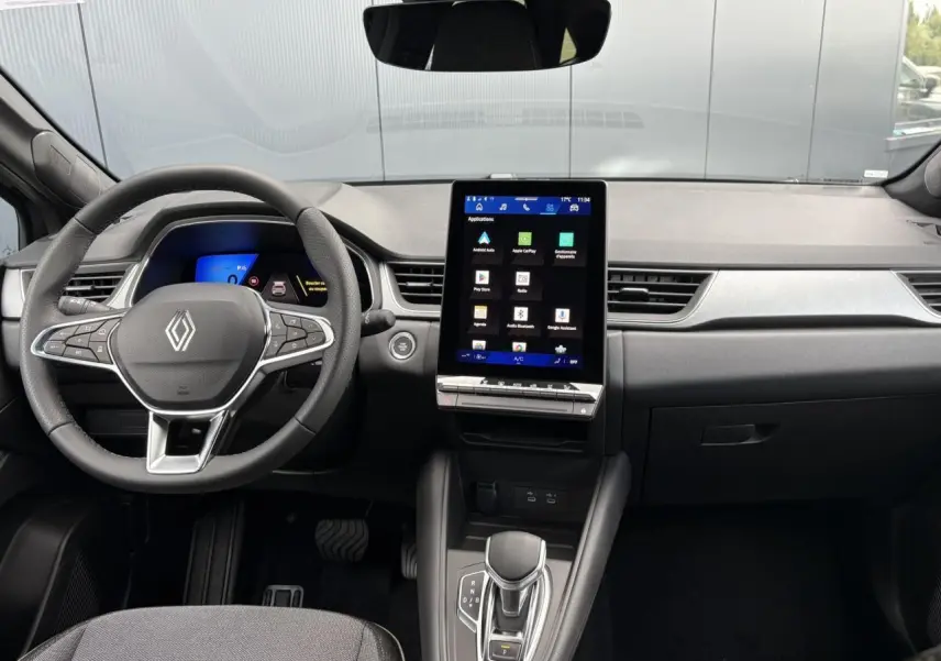Vue intérieure frontale du tableau de bord et volant Renault Symbioz 2025 avec écran tactile vertical et commandes au volant.