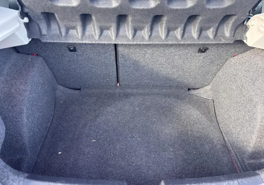 Coffre vide de la SEAT Ibiza 1.2 TSI Style 2016, vue intérieure arrière avec revêtement gris foncé.