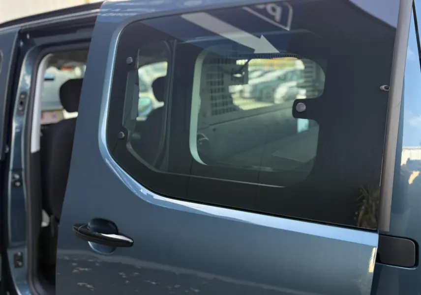 Porte latérale coulissante droite bleu métallisé du Citroën Berlingo Multispace 2025, vue rapprochée avec intérieur partiellement visible.