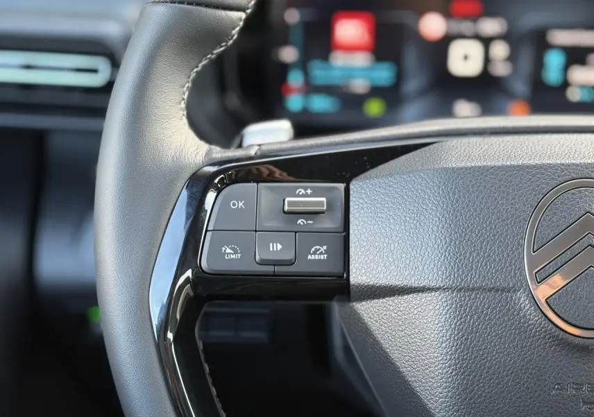 Gros plan sur la partie gauche du volant cuir noir du Citroën Berlingo Multispace 2025 avec commandes multifonctions.