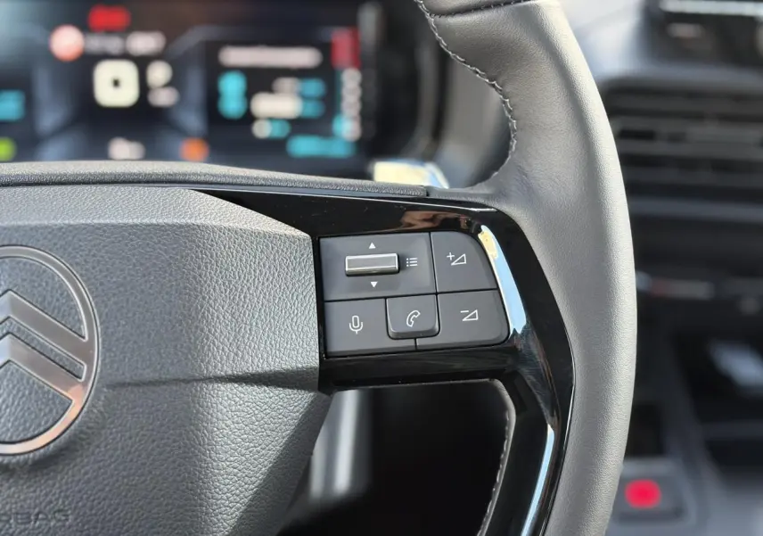 Gros plan sur le volant en cuir multifonctions du Citroën Berlingo Multispace 2025, avec commandes audio et téléphone.
