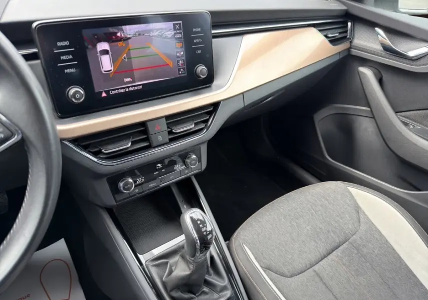 Vue rapprochée du combiné d'instruments du Skoda Kamiq 2023, affichant autonomie et compteurs analogiques.