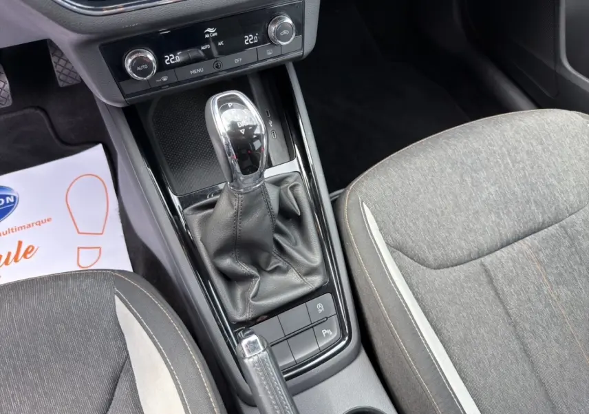 Vue rapprochée de l’écran tactile central et de la console de climatisation du Skoda Kamiq 2023, intérieur noir avec insert bois clair.