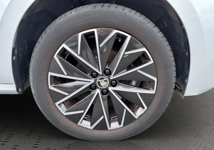 Vue avant d'un Skoda Kamiq gris clair 2023 avec calandre noire et logo distinctif au centre.