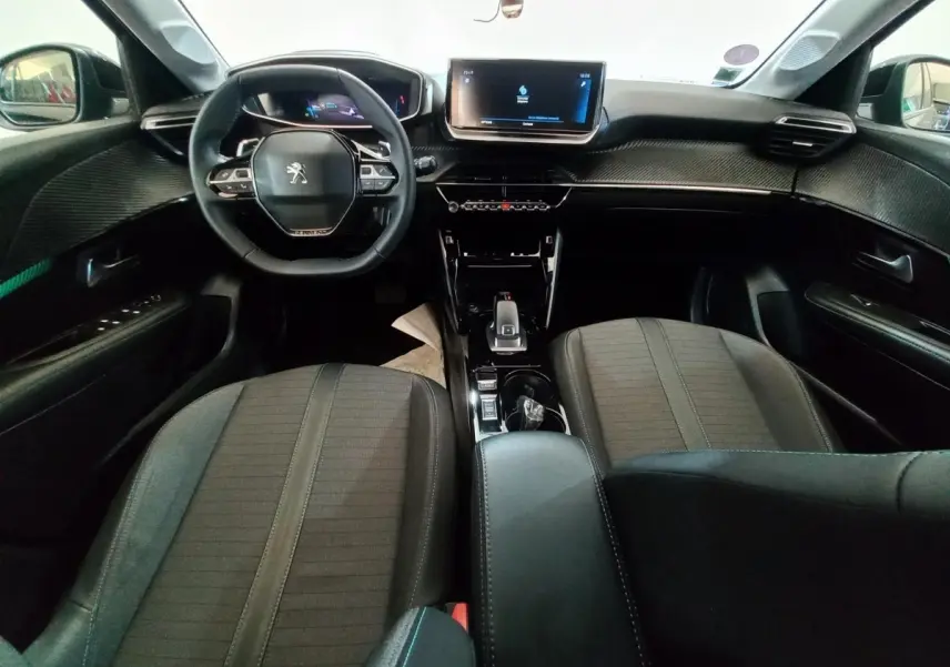 Vue intérieure avant de la Peugeot 208 noire, avec tableau de bord digital et écran tactile central lumineux.
