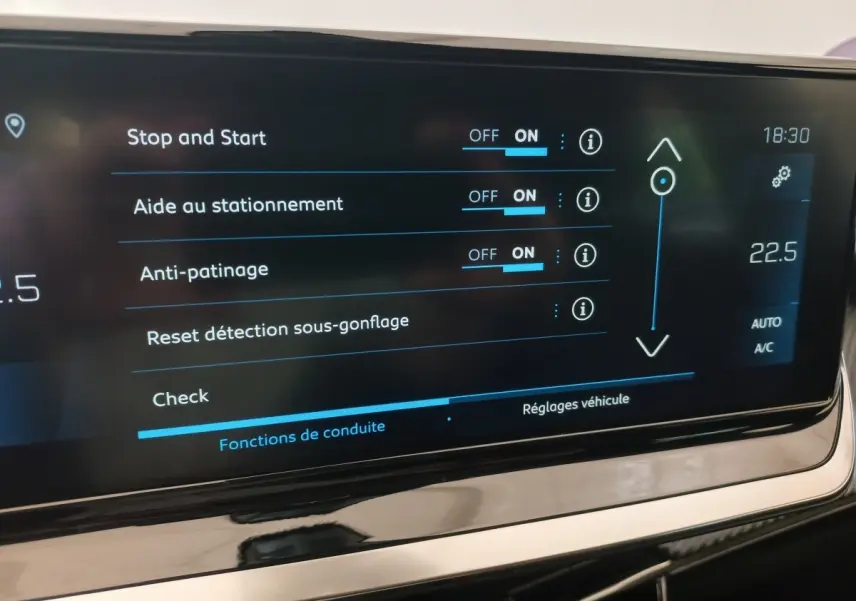 Écran tactile central affichant les réglages d’aide à la conduite dans une Peugeot 208 noire, vue intérieure rapprochée.