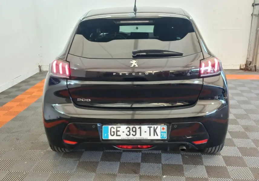 Vue arrière d’une Peugeot 208 noire 2022 avec feux arrière LED allumés et plaque d’immatriculation française.