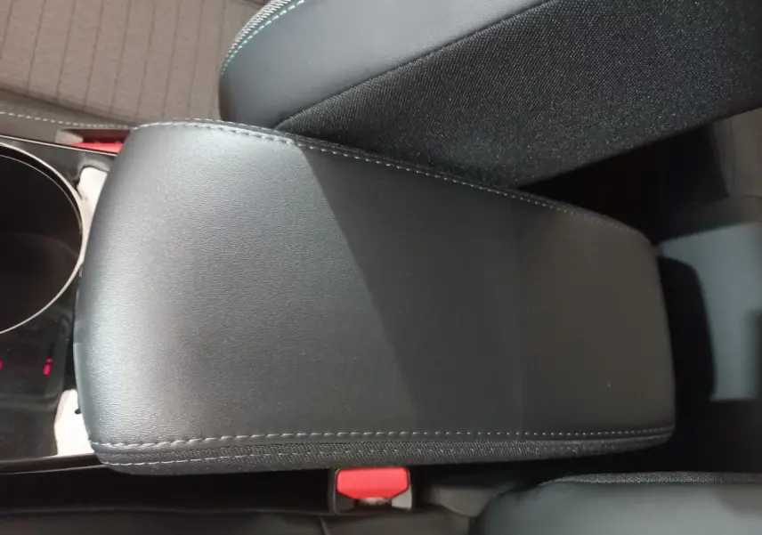 Détail de l'accoudoir central noir en cuir avec surpiqûres, intérieur de la Peugeot 208 PureTech 100 Allure Pack 2022.