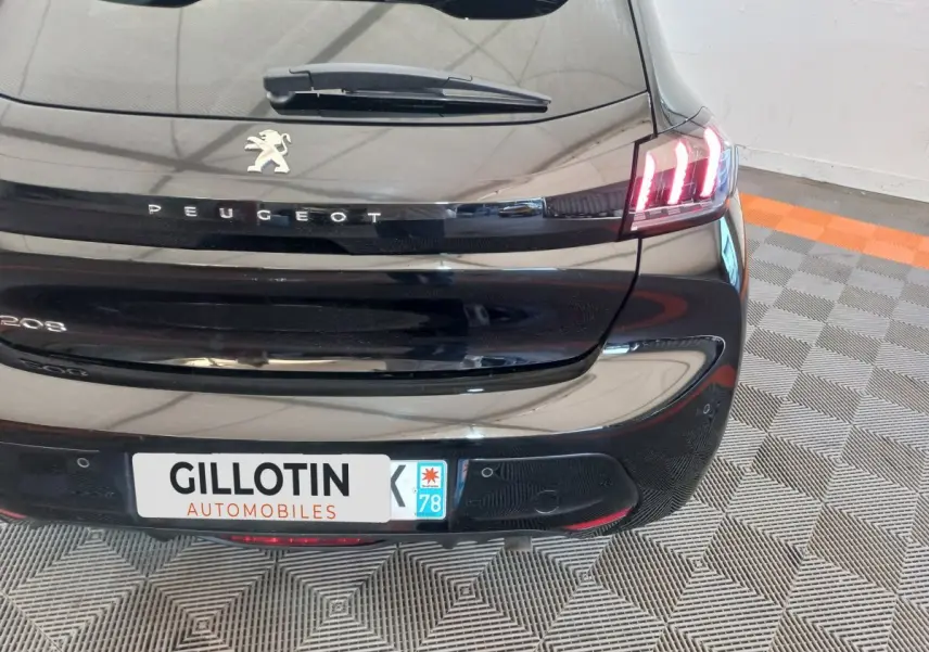 Vue arrière droite d'une Peugeot 208 noire 2022 avec feux LED distinctifs et logo Peugeot visible.