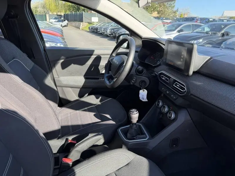 Vue intérieure côté conducteur du Dacia Jogger 2025, montrant le volant, la boîte manuelle et l'écran central.
