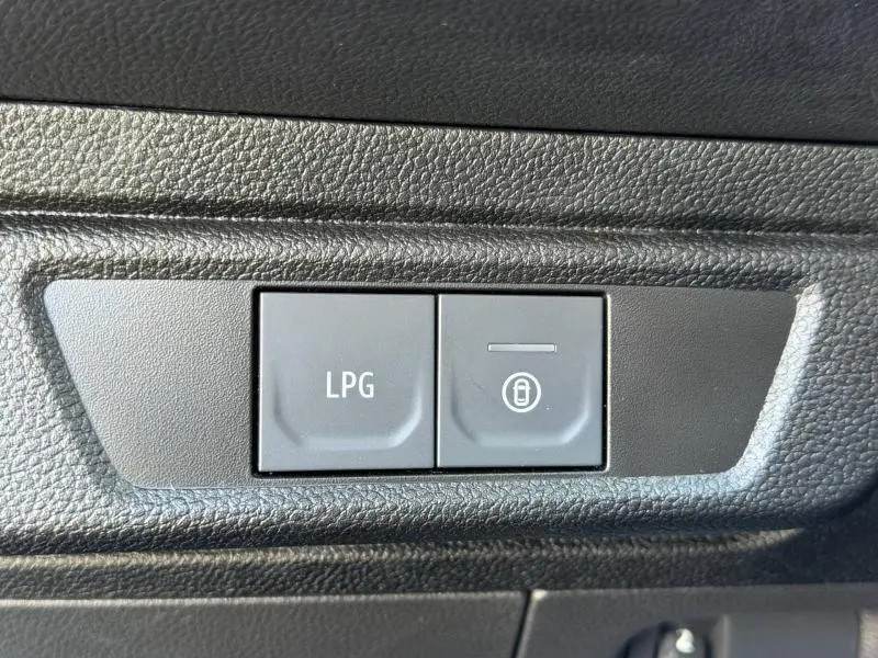 Boutons intérieurs en gros plan du Dacia Jogger 2025, avec commande LPG sur fond noir texturé.