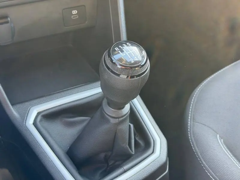 Gros plan sur le levier de vitesses manuel du Dacia Jogger 2025, entouré d’une console noire avec surpiqûres grises.