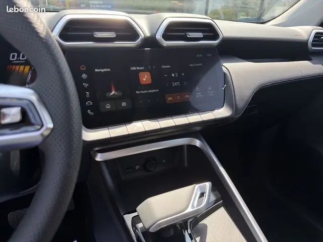 Vue intérieure avant de la MG ZS 1.5 L Hybrid+ 197ch Luxury, tableau de bord moderne et sièges cuir noirs.