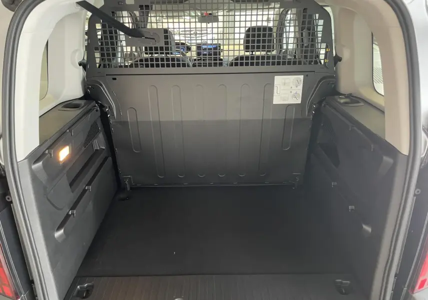 Vue arrière du coffre spacieux du Peugeot Rifter gris Artense avec cloison de séparation métallique noire.