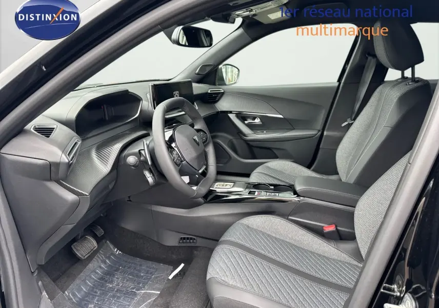 Intérieur avant droit du Peugeot 2008 noir métal 2025, sièges tissu gris et tableau de bord moderne avec écran central.