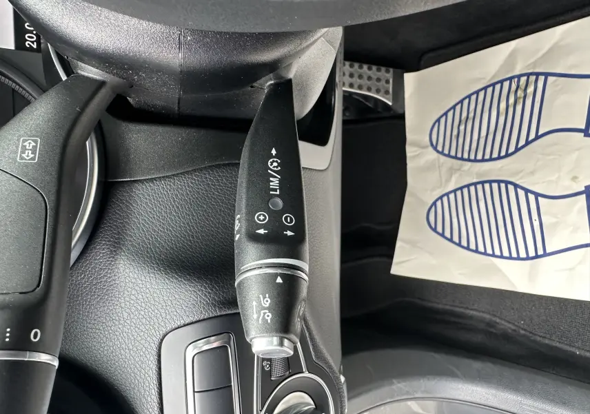 Gros plan sur la commande de régulateur de vitesse dans l'habitacle noir d'un Mercedes GLC Coupé gris foncé 2018.