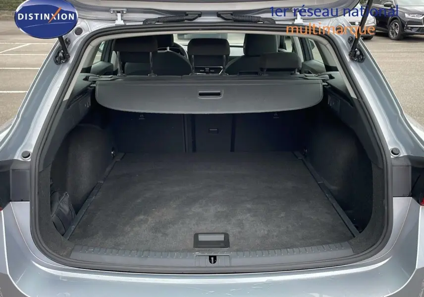 Coffre ouvert d'une SEAT LEON ST gris urbain 2023, vue arrière montrant l'espace de chargement vide et la plage arrière.