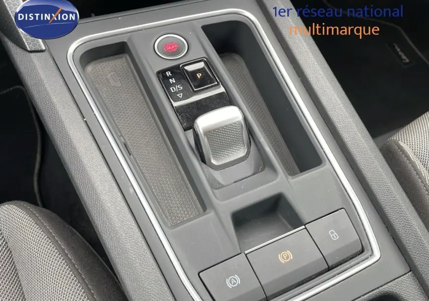 Gros plan sur la console centrale grise avec levier de boîte automatique et bouton start/stop d'une SEAT LEON ST 2023.