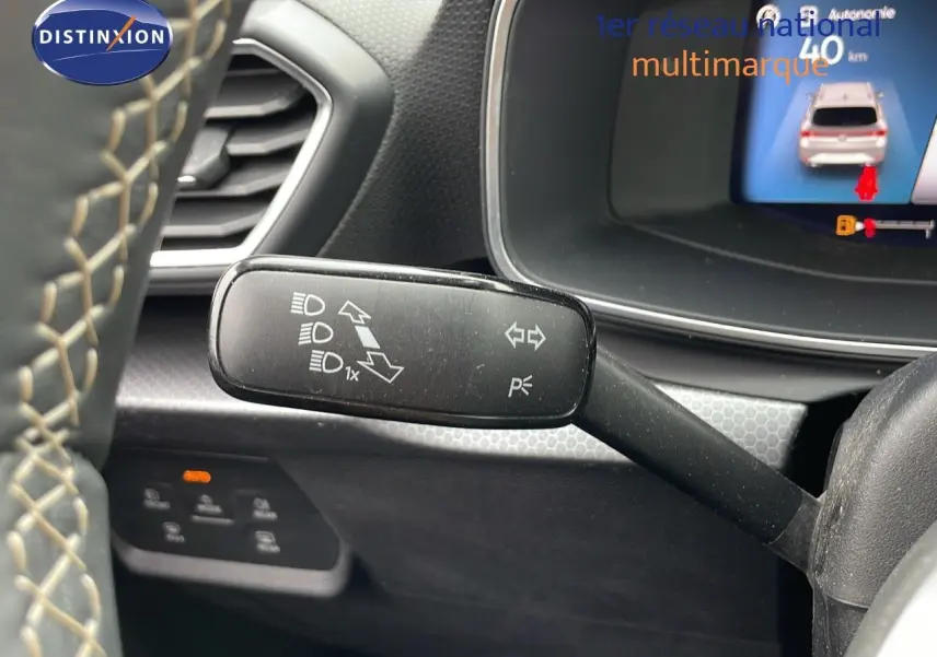 Le levier de clignotant noir avec pictogrammes, près du volant d'une SEAT Leon ST gris urbain 2023, intérieur moderne.