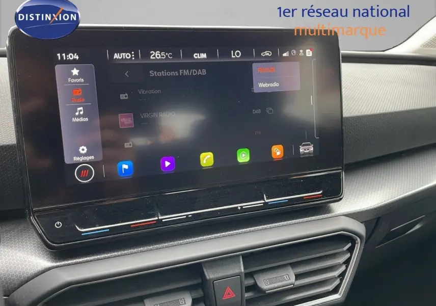 Écran tactile central affichant la radio FM/DAB dans l'habitacle gris noir d'une SEAT LEON ST 2023.
