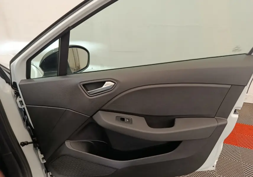 Vue intérieure de la porte avant gauche blanche d'une Renault Clio 2023, avec poignée argentée et panneau noir.