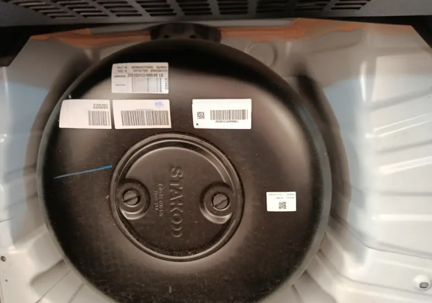 Vue rapprochée du réservoir GPL noir circulaire dans le coffre d’une Renault Clio blanche Evolution TCe 100 GPL.