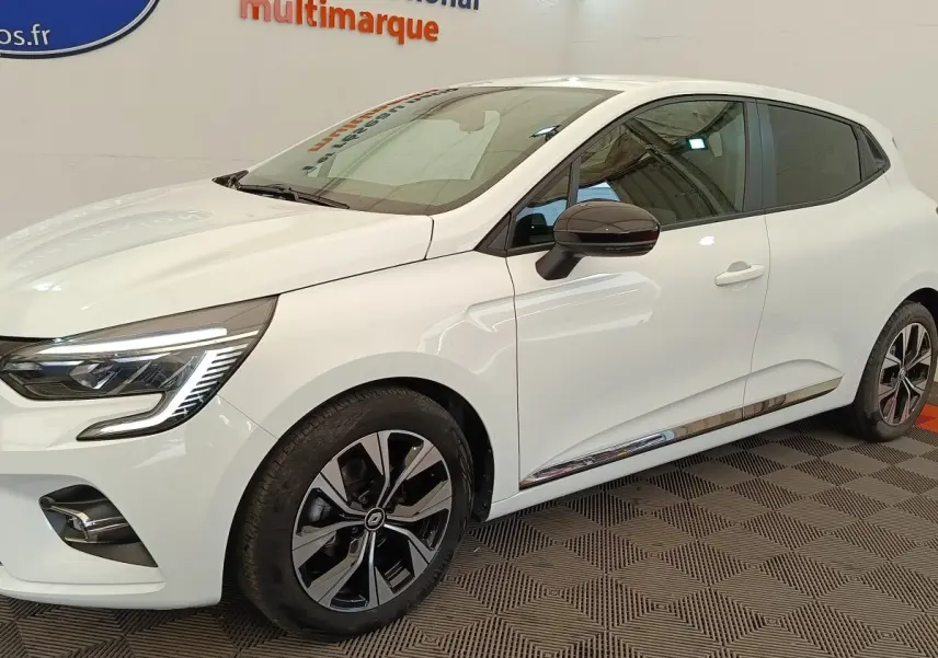 Vue 3/4 avant droit d'une Renault Clio blanche Evolution TCe 100 GPL avec jantes noires et rétroviseurs noirs.