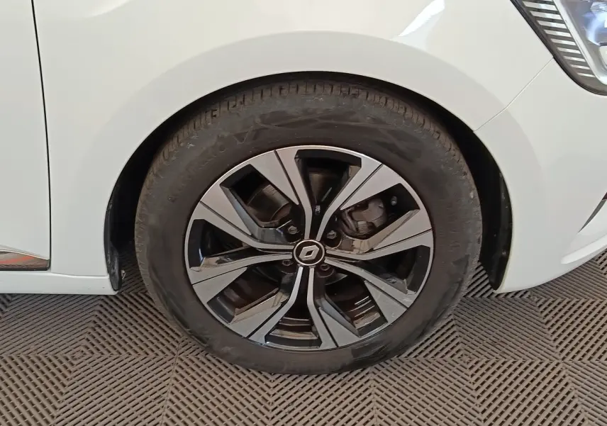 Gros plan sur la roue avant droite de la Renault Clio blanche Evolution TCe 100 GPL avec jante alliage noire et argent.