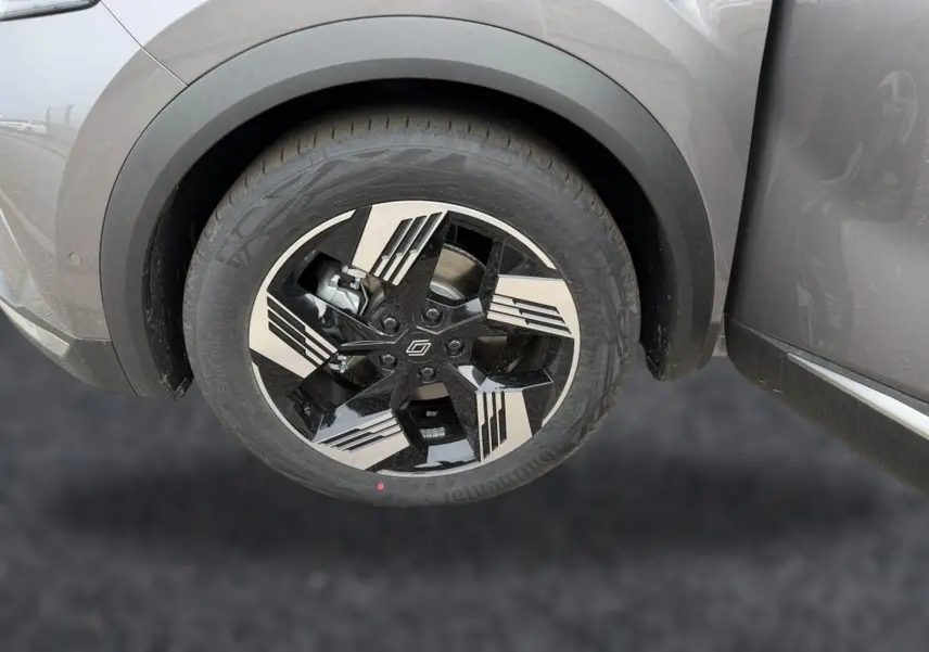 Gros plan sur la roue avant gauche du Renault Symbioz gris cassiopée avec jante alu noire et argentée au design géométrique.