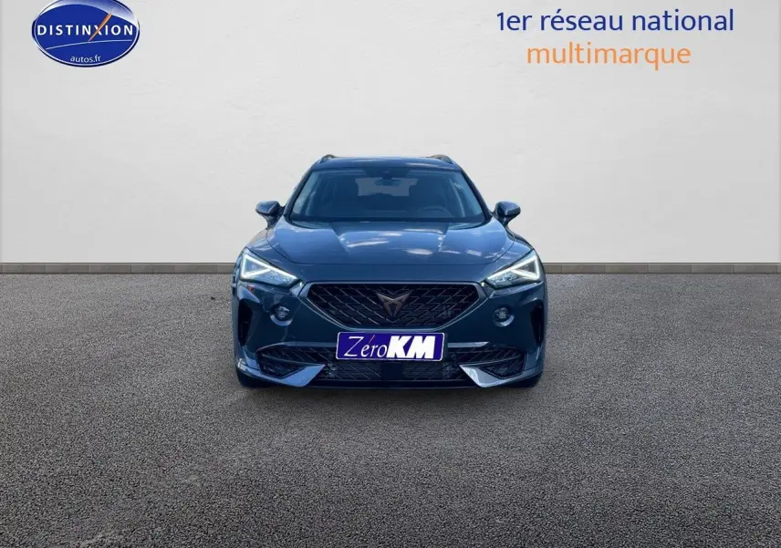 Vue frontale d'un CUPRA Formentor gris magnétique 2024 avec calandre noire et feux LED anguleux allumés.