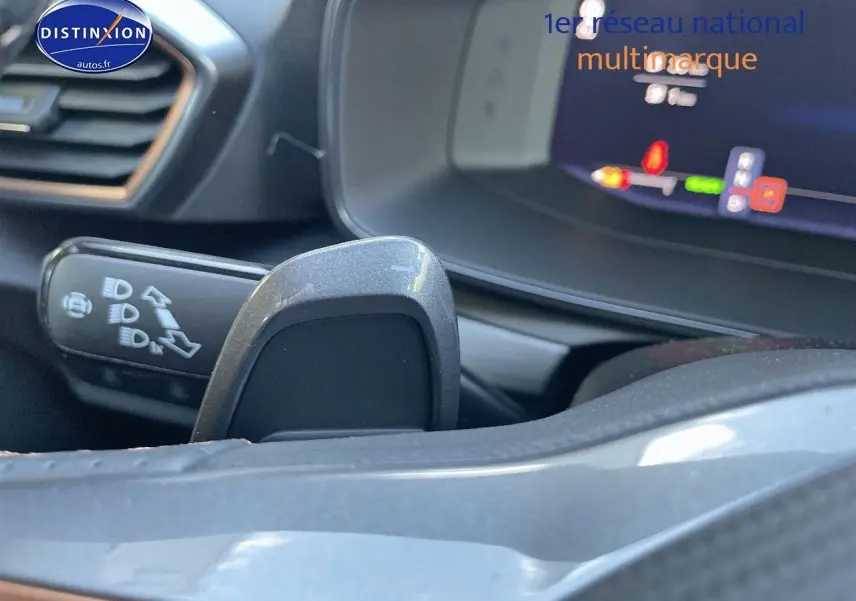 Gros plan sur la commande de clignotant et le volant partiel d'une CUPRA Formentor gris magnétique, tableau de bord numérique visible.