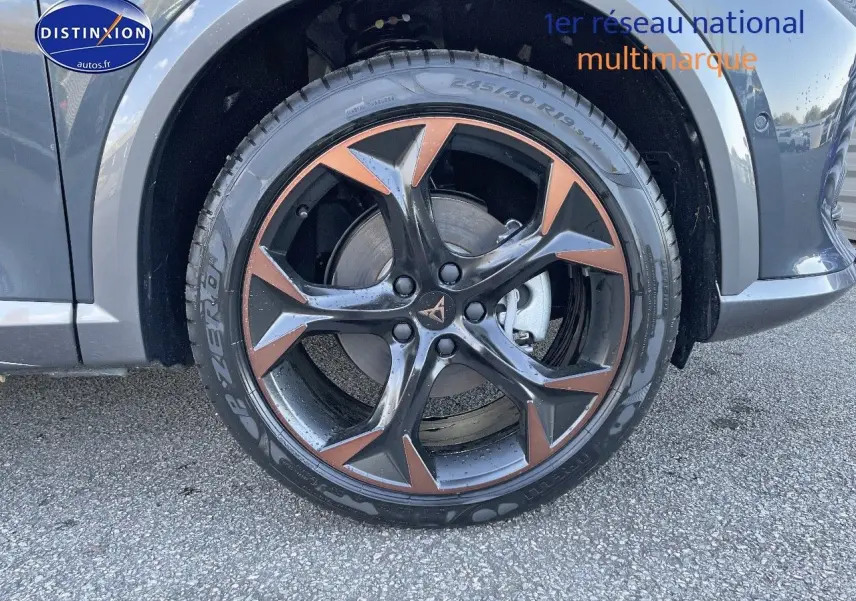 Gros plan sur la roue avant droite du CUPRA Formentor gris magnétique, mettant en valeur la jante noire et cuivrée au design sportif.