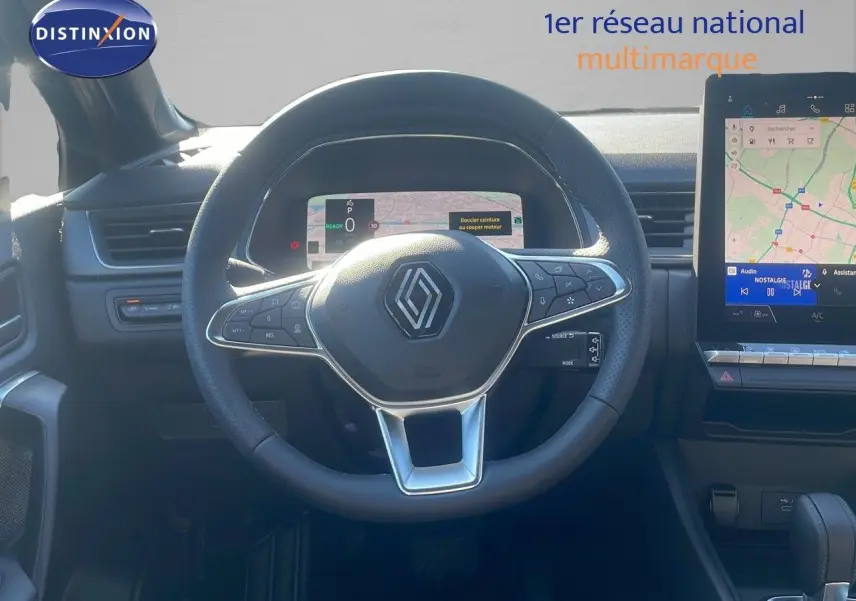 Vue intérieure centrée sur le volant Renault noir avec tableau de bord numérique et écran tactile multimédia à droite