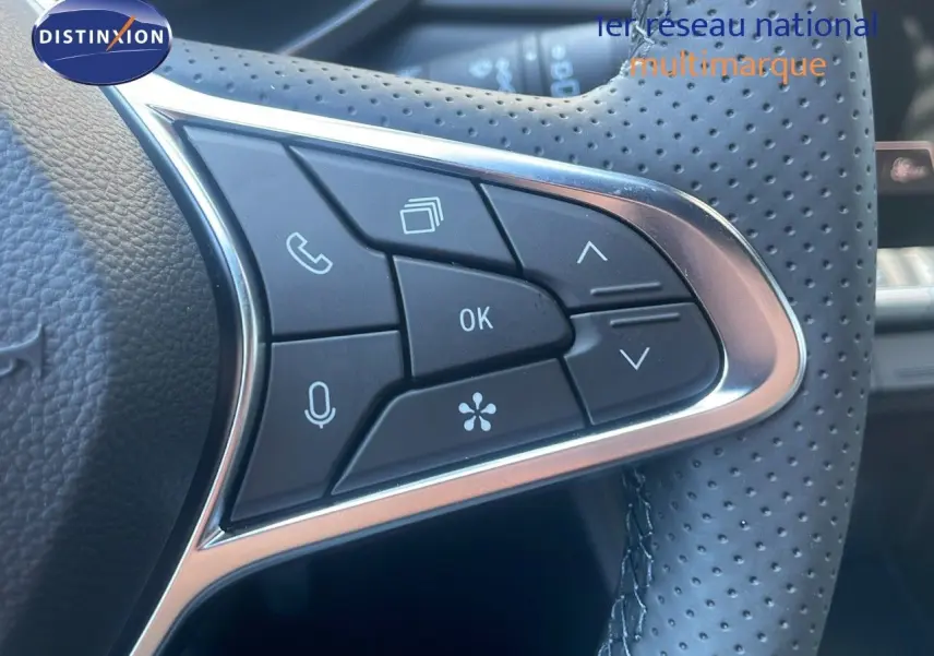 Détail du volant en cuir perforé du Renault Captur noir étoile métal, avec commandes multifonctions intégrées.