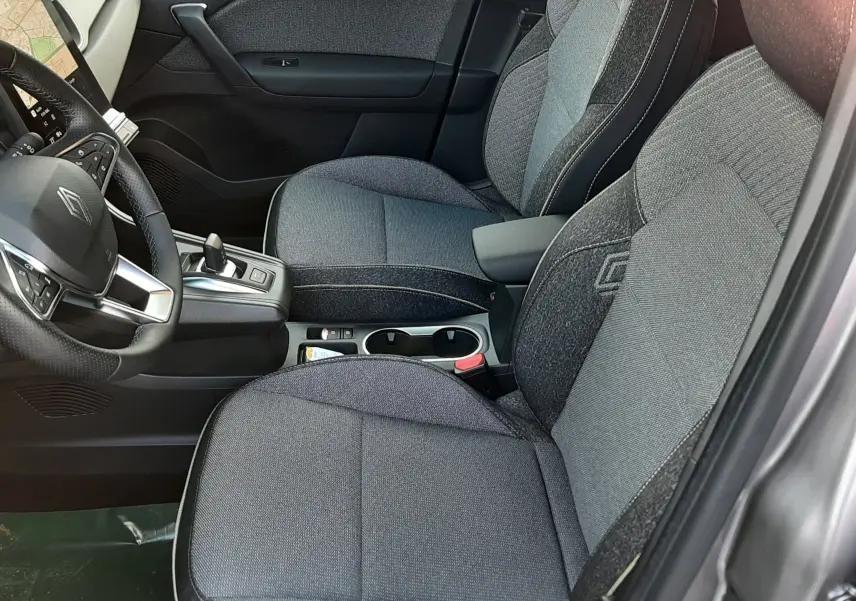 Intérieur du Renault Captur 2025 en gris Cassiopée, vue côté droit sur les sièges tissu gris et la console centrale.