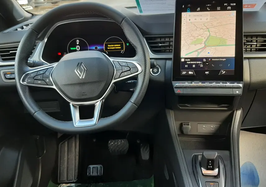 Vue intérieure avant du tableau de bord du Renault Captur gris Cassiopée 2025, avec volant multifonction et écran tactile central.