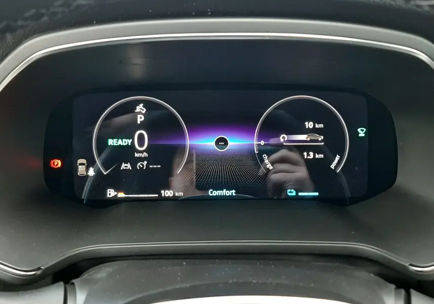 Vue rapprochée du tableau de bord numérique du Renault Captur gris Cassiopée 2025, affichant la vitesse et l'autonomie hybride.