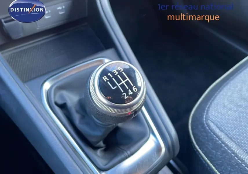 Gros plan sur le levier de vitesses manuel du Renault Captur 2025, entouré de garnitures noires et tissu gris du siège.