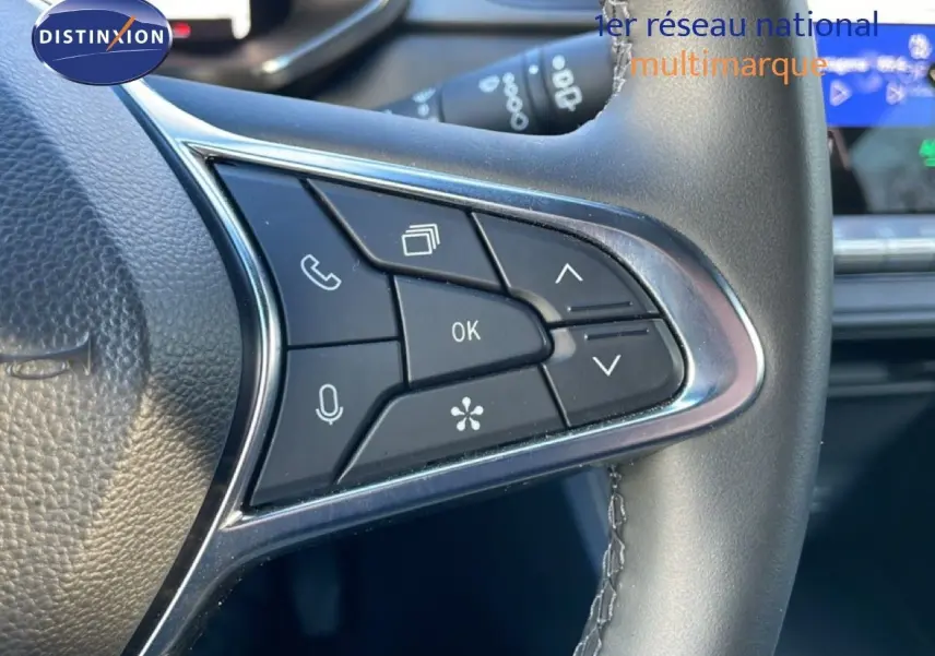 Gros plan sur les commandes au volant en cuir noir du Renault Captur 2025, avec boutons multifonctions et finition chromée.