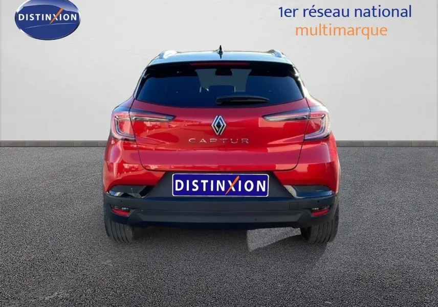 Vue arrière d'un Renault Captur 2025 rouge Désir Métal avec toit noir, mettant en valeur ses feux et son logo central.