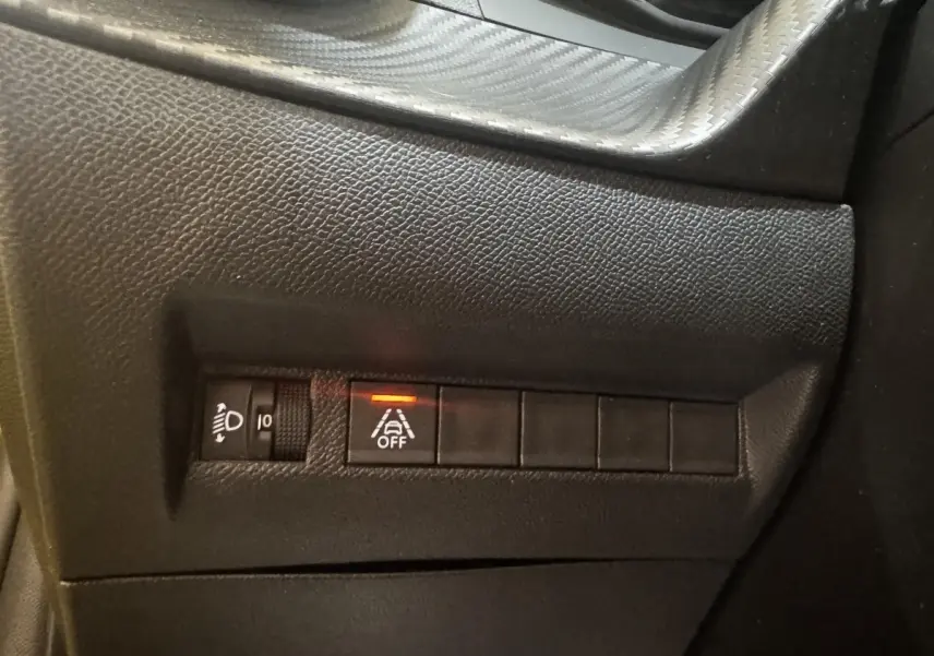 Gros plan sur les commandes noires du tableau de bord côté gauche de la Peugeot 208 jaune PureTech 75 S&S Active Pack 2023.