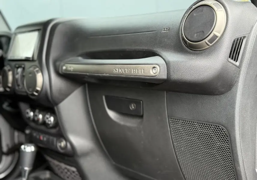 Vue intérieure côté passager du tableau de bord noir de la Jeep Wrangler 2019 avec poignée "Since 1941" visible.