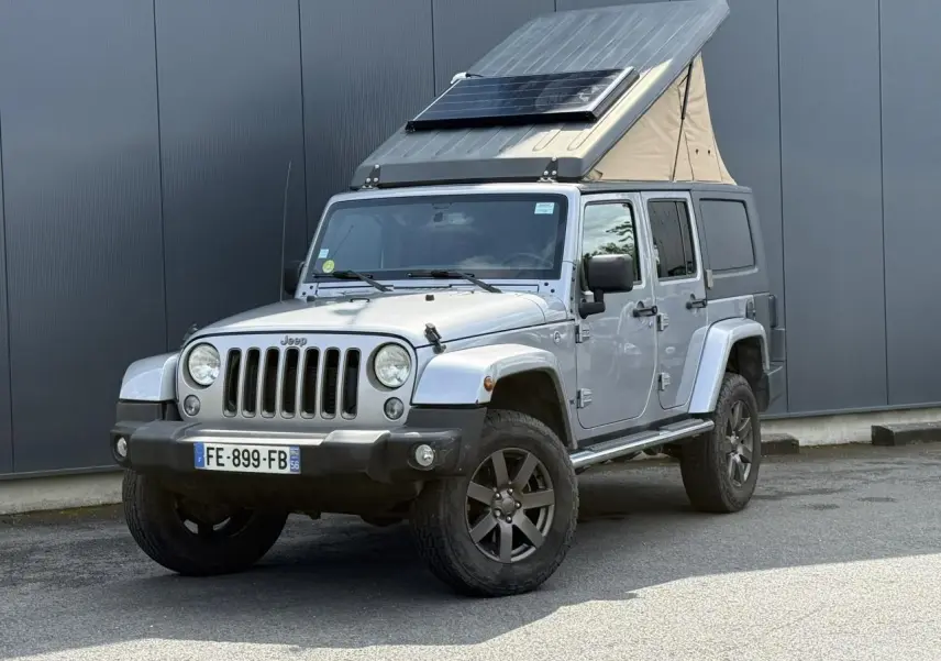 Jeep Wrangler Billet Silver vue 3/4 avant gauche avec toit relevable et panneau solaire sur le toit.